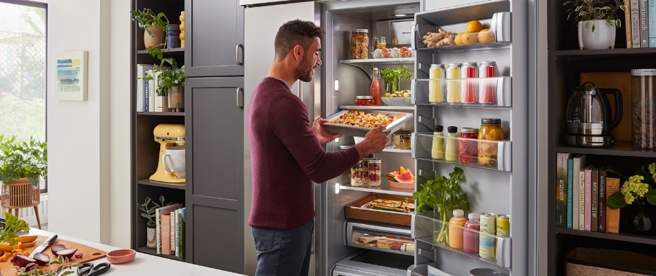 man cooking using kitchenaid refrigerator